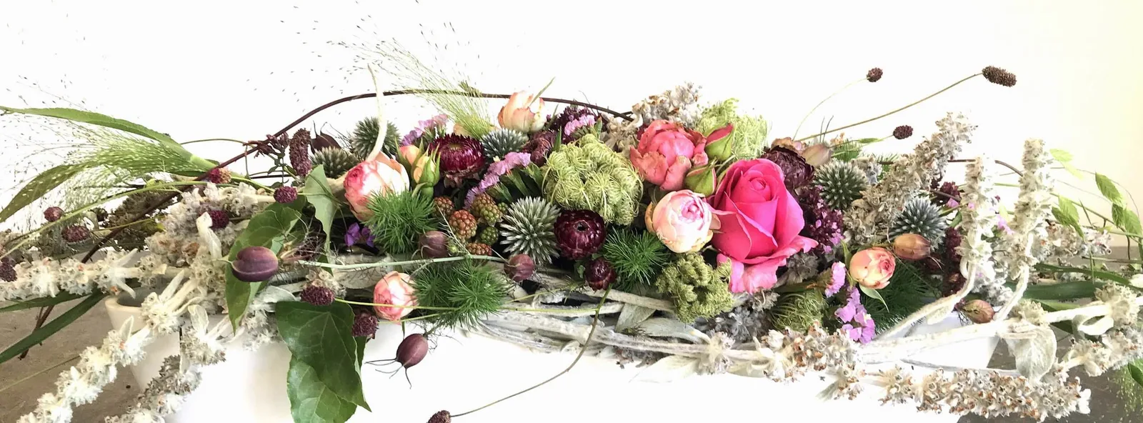 Onlinekurs 1x1 Floristik - Vielfalt der Kränze Hero-Banner mit üppigem Blumenkranz aus Rosen, Distel, Gräsern und Trockenblum