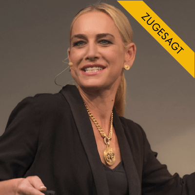 Porträt von Katja Porsch, blonde Frau in schwarzem Blazer mit Gold-Kette