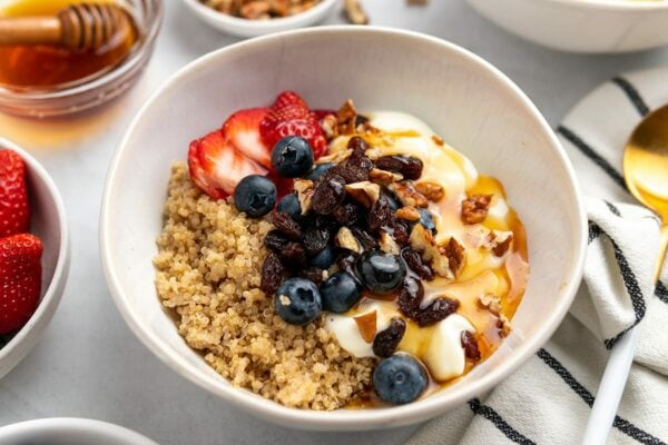 Quinoa-Schüssel mit Joghurt, frischen Beeren, Schokoladen-Chips und Honig