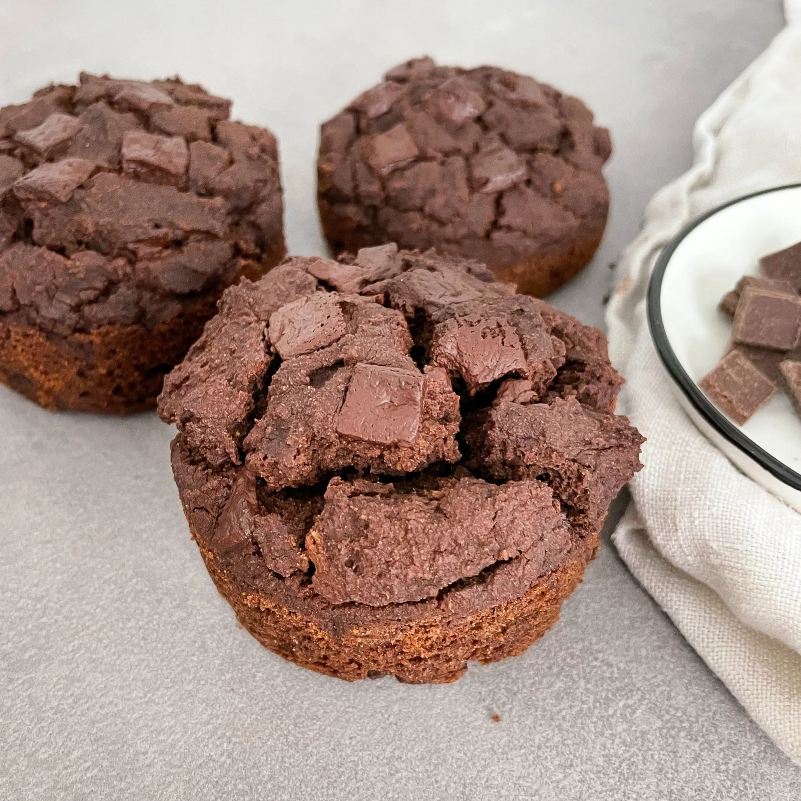 Schokoladen-Muffins mit Rissen auf heller Oberfläche