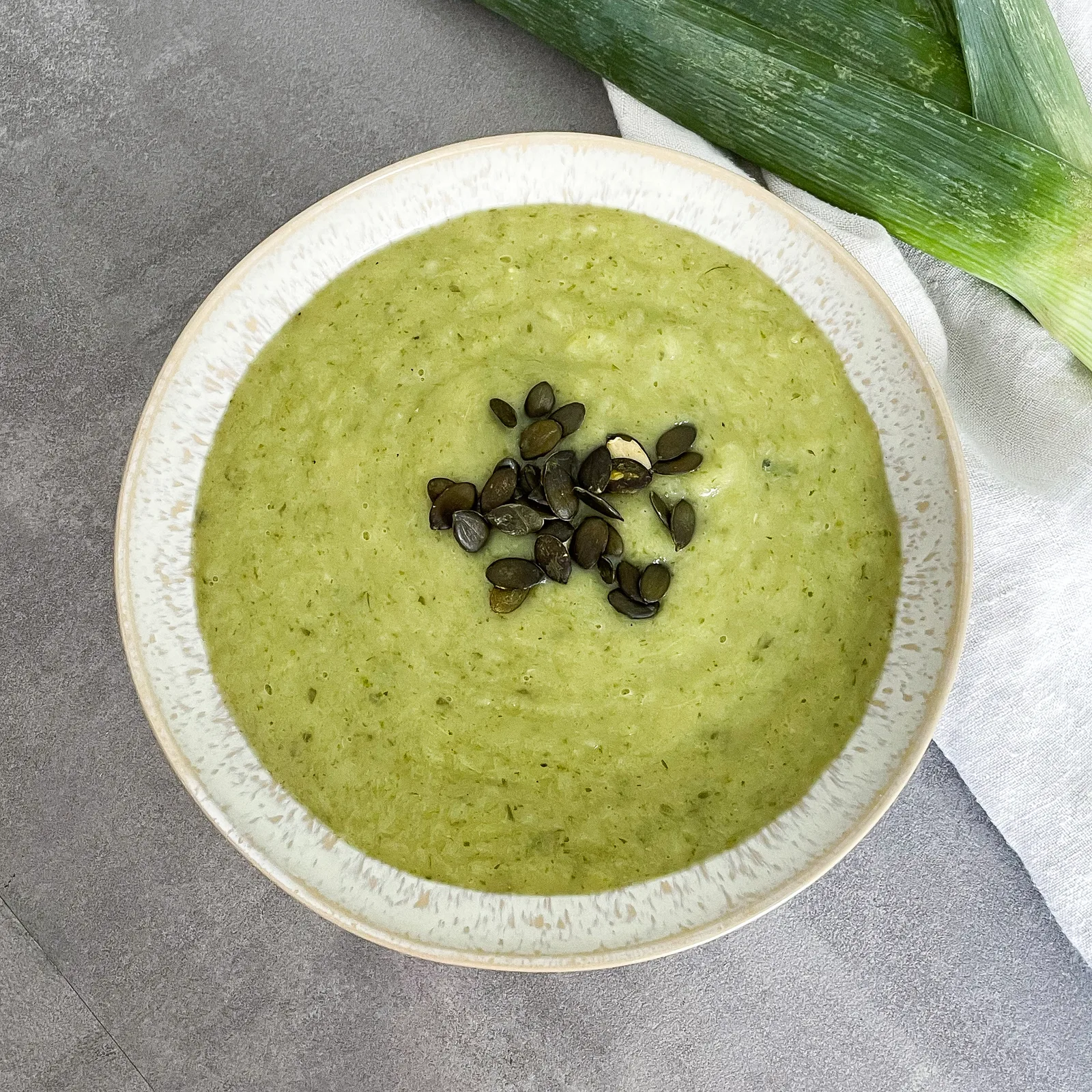 Kartoffel-Lauch-Suppe in weißer Schale mit Kürbiskernen