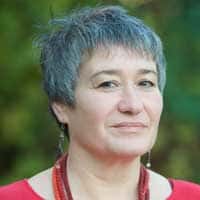 Porträtfoto von Manuela Mätzener, Frau mit grauem Haar und rotem Oberteil