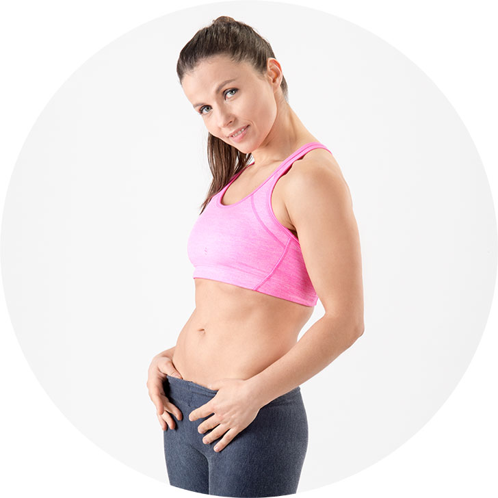 12 Wochen Fatburner Abnehmprogramm – Videokurs zum Abnehmen 9 Frau in pinkem Sport-Top zeigt Bauchmuskulatur, Nachher-Foto eines Abnehmprogramms