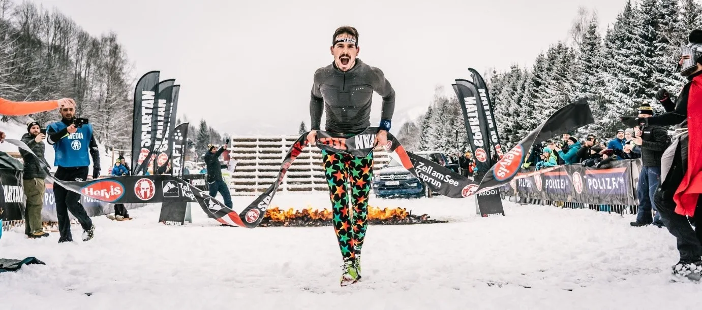 Lucas Kempe läuft jubelnd über die Ziellinie beim OCR-Wettkampf in Kaprun im Schnee
