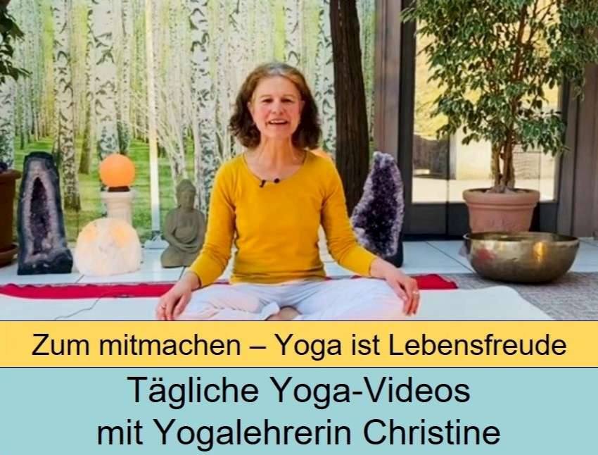 Yogalehrerin Christine in gelbem Langarmshirt auf Meditationsmatte sitzend vor dekorativen Objekten und Birkenwaldkulisse