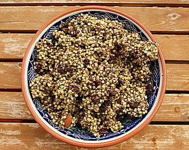 Schale mit Quinoa Granola auf Holztisch in Keramikschüssel