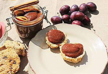 Zwei Frucht-Scones mit roten Früchten und Marmelade neben Pflaunen