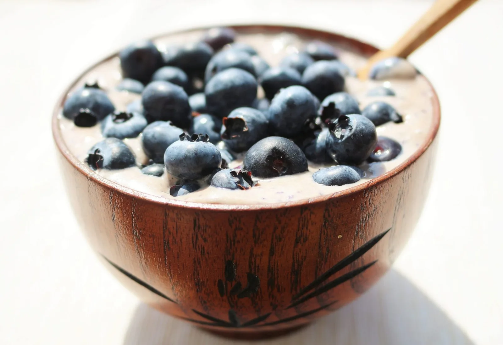 Joghurt-Schale mit Blaubeeren in brauner Holzschüssel