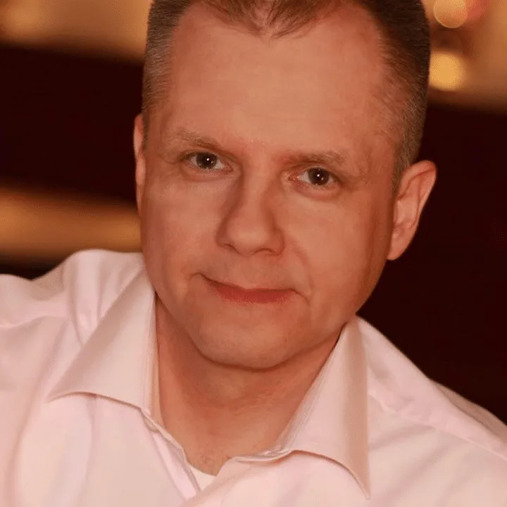 Mann in hellem rosa Hemd, ernster Blick, Portrait mit warmer Beleuchtung
