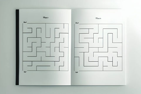 Offenes Arbeitsbuch mit zwei Labyrinthen mittlerer Schwierigkeit nebeneinander