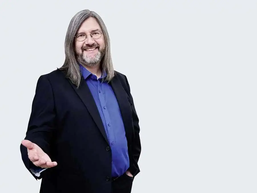 Michael Smetana Porträt, Mann in schwarzem Blazer mit blauem Hemd