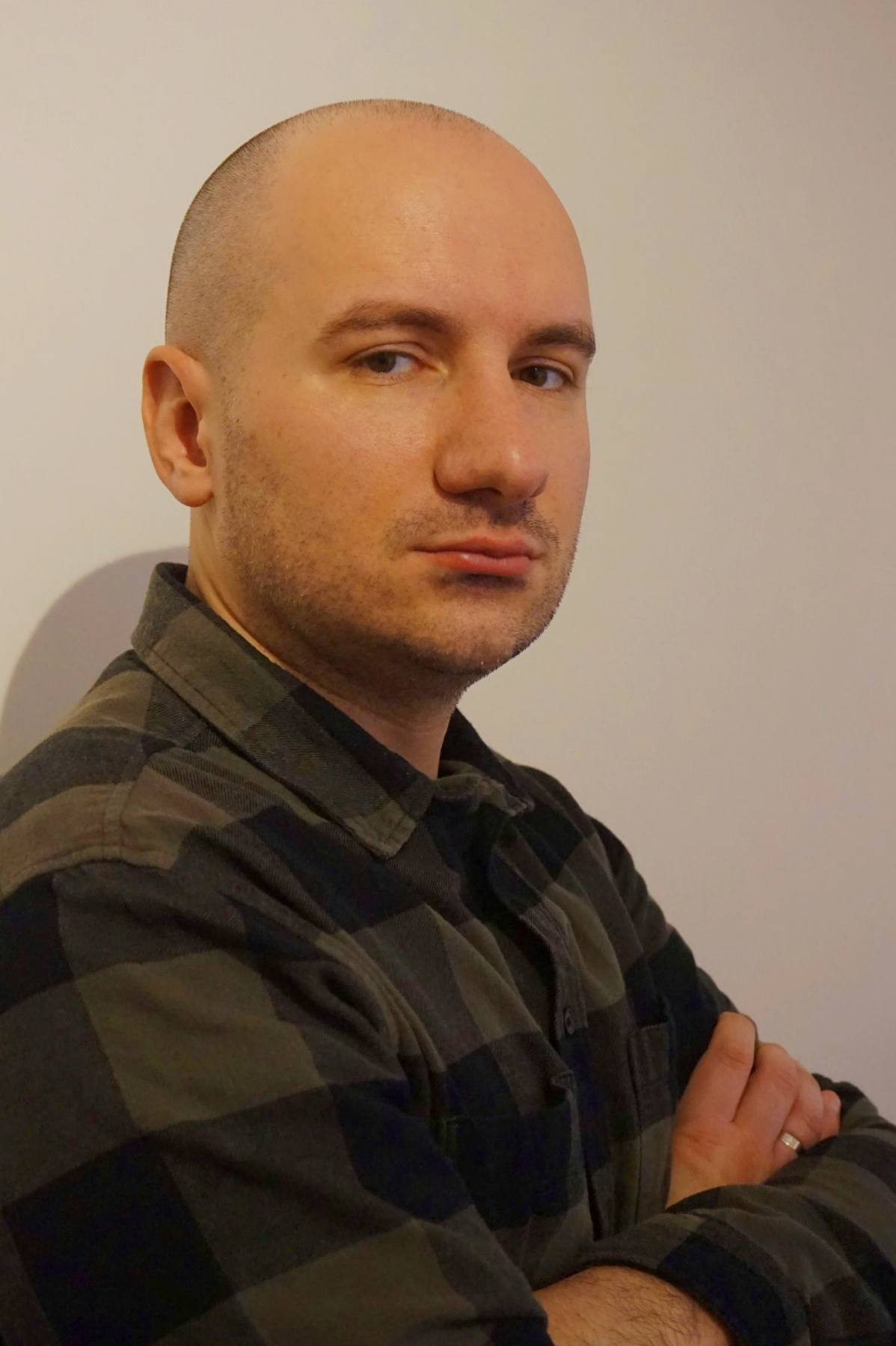 Portrait eines Mannes in dunklem Hemd mit ernstem Blick zur Seite