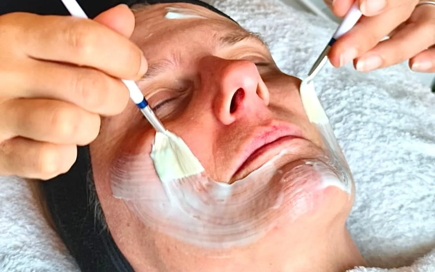 Professionelle Gesichtsbehandlung mit Pinsel auf männlichem Gesicht, Hautmaske