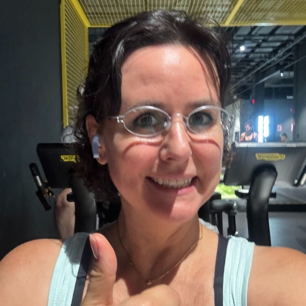 Olga, Frau mit Brille und rötlichen Haaren im Wohnzimmer