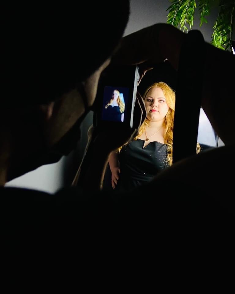 Model in schwarzem Kleid beim professionellen Fotoshooting, Kameras und Lichttechnik sichtbar