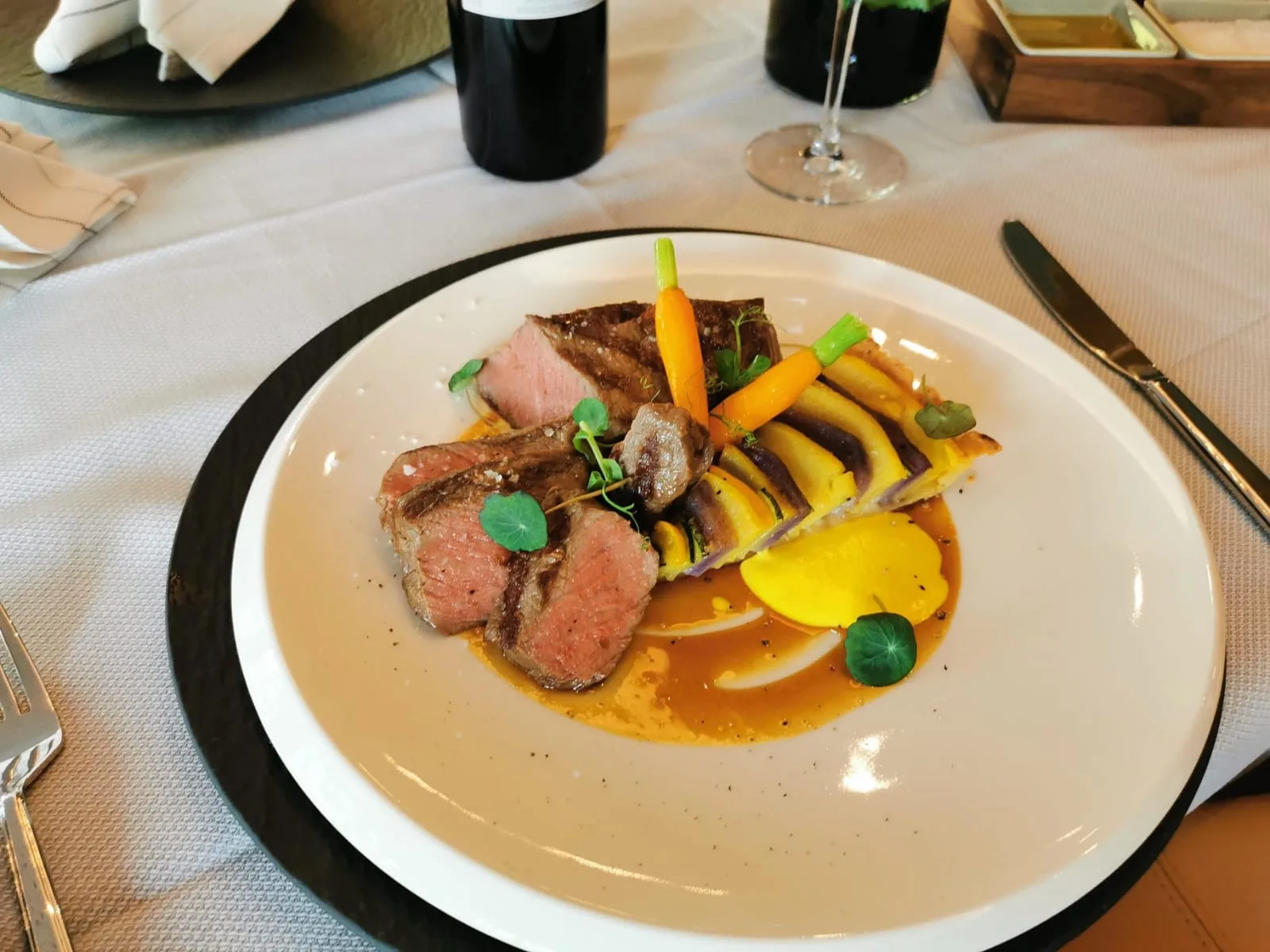 Gourmet-Teller mit rosa Entenbrust, Gemüsespießen und gelber Sauce im Restaurant