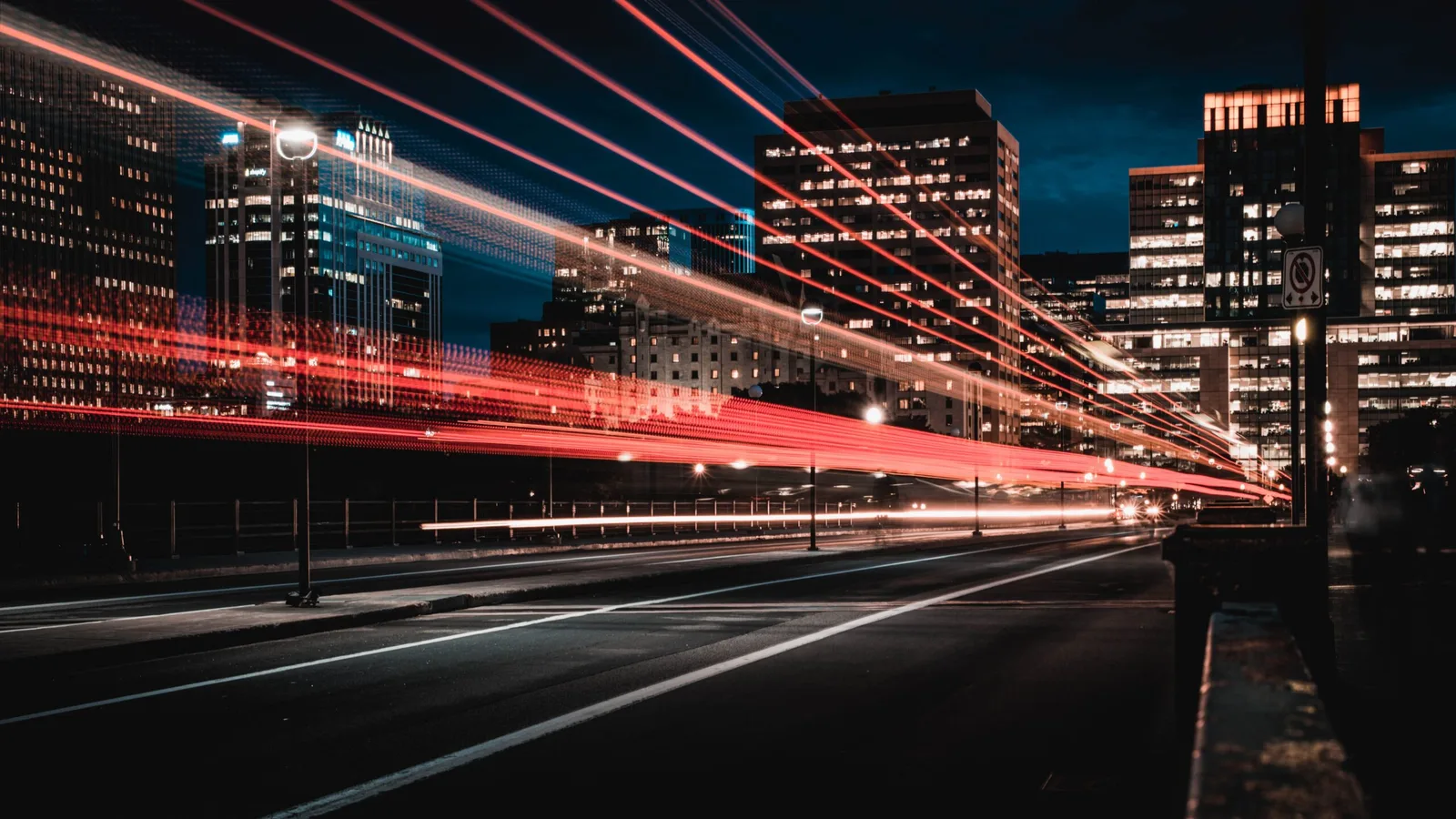 Nachtstadtszene mit roten Lichtspuren von Fahrzeugen, Hochhäuser beleuchtet