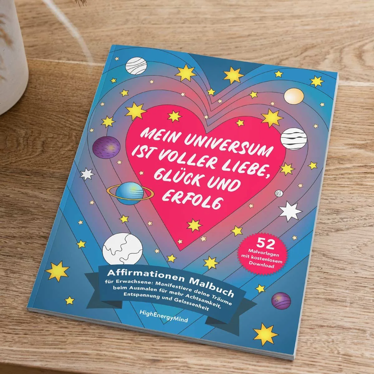 Affirmationen Malbuch auf Holztisch neben Pflanze und Stiftbox