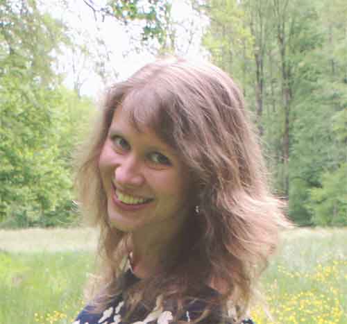 Porträt Stella Schirjaew, Sprecherin des Hörbuchs, vor Naturhintergrund mit lächelndem Gesicht