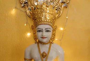 Lächelnder Buddha mit Krone und Lichterkette, visuelles Symbol für das Programm Alles Liebe