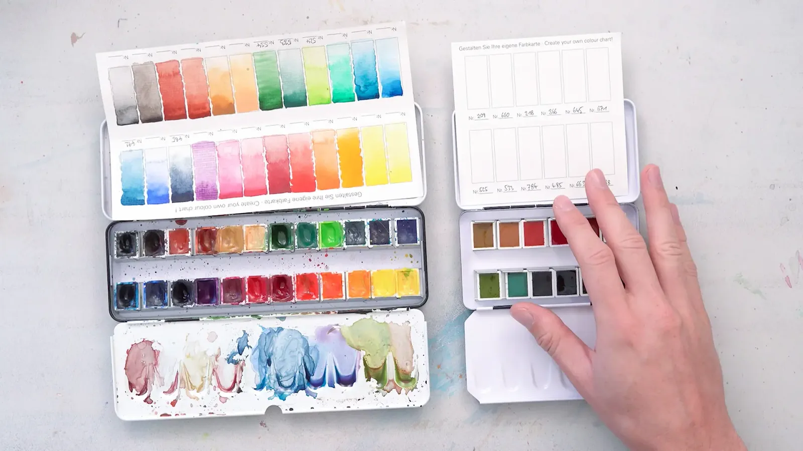 Farbmischungs-Referenzkarten und Aquarell-Palette mit Testblättern