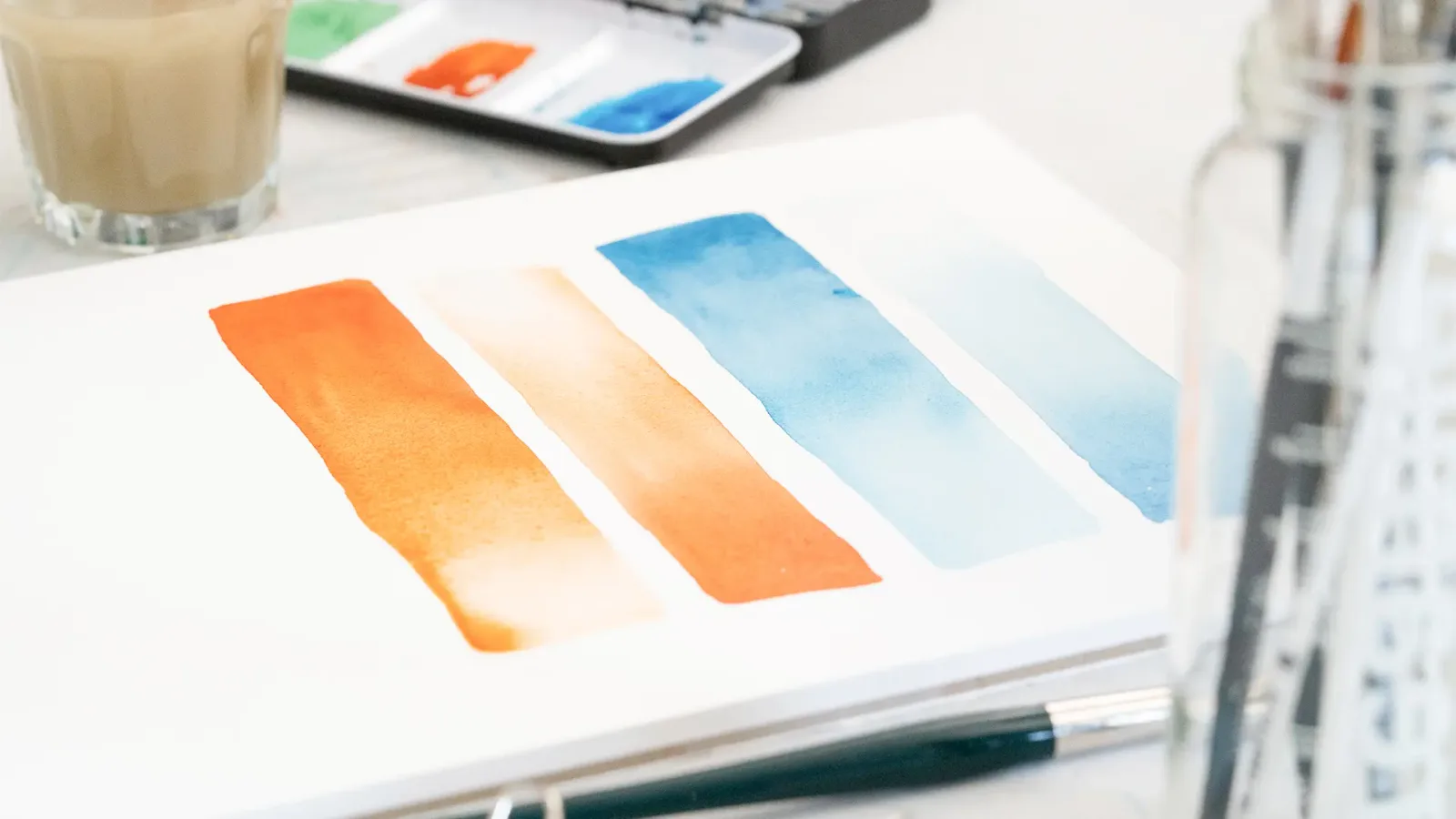 Aquarell-Farbverläufe in Orange, Aprikose und Blau auf Papier