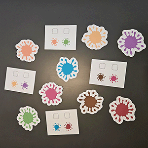 Farbkleckse-Spiel mit weißen Blütenformen in verschiedenen Farben und Farbkombinationskarten