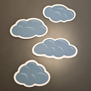 Vier ausdruckbare blaue Wolkensticker mit weißem Rand auf grauem Hintergrund