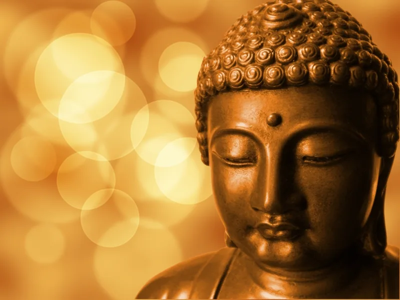 Buddha-Statue aus Bronze mit unscharfem goldenem Bokeh-Hintergrund