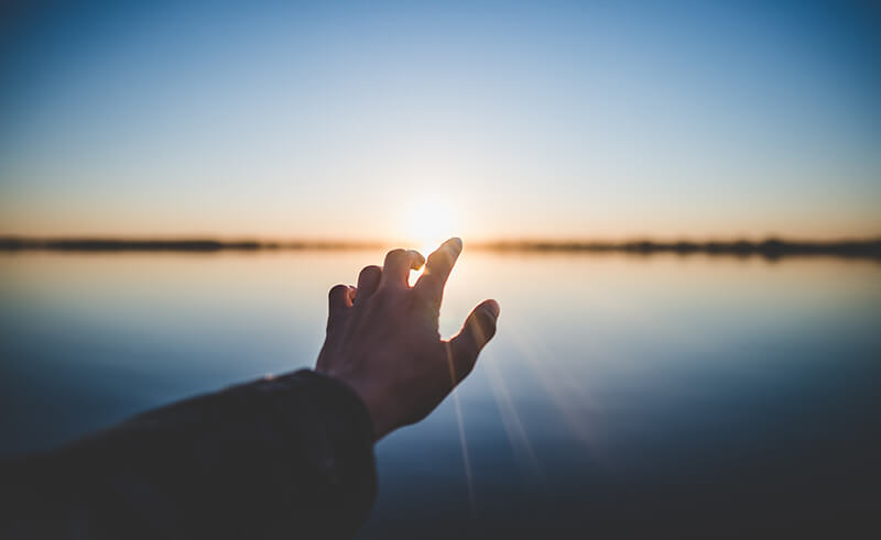 Autogenes Training Grundstufe – Videokurs zur Entspannung 4 Hand vor Wasser und Sonnenaufgang, Licht durchdringend, Entspannungsszene
