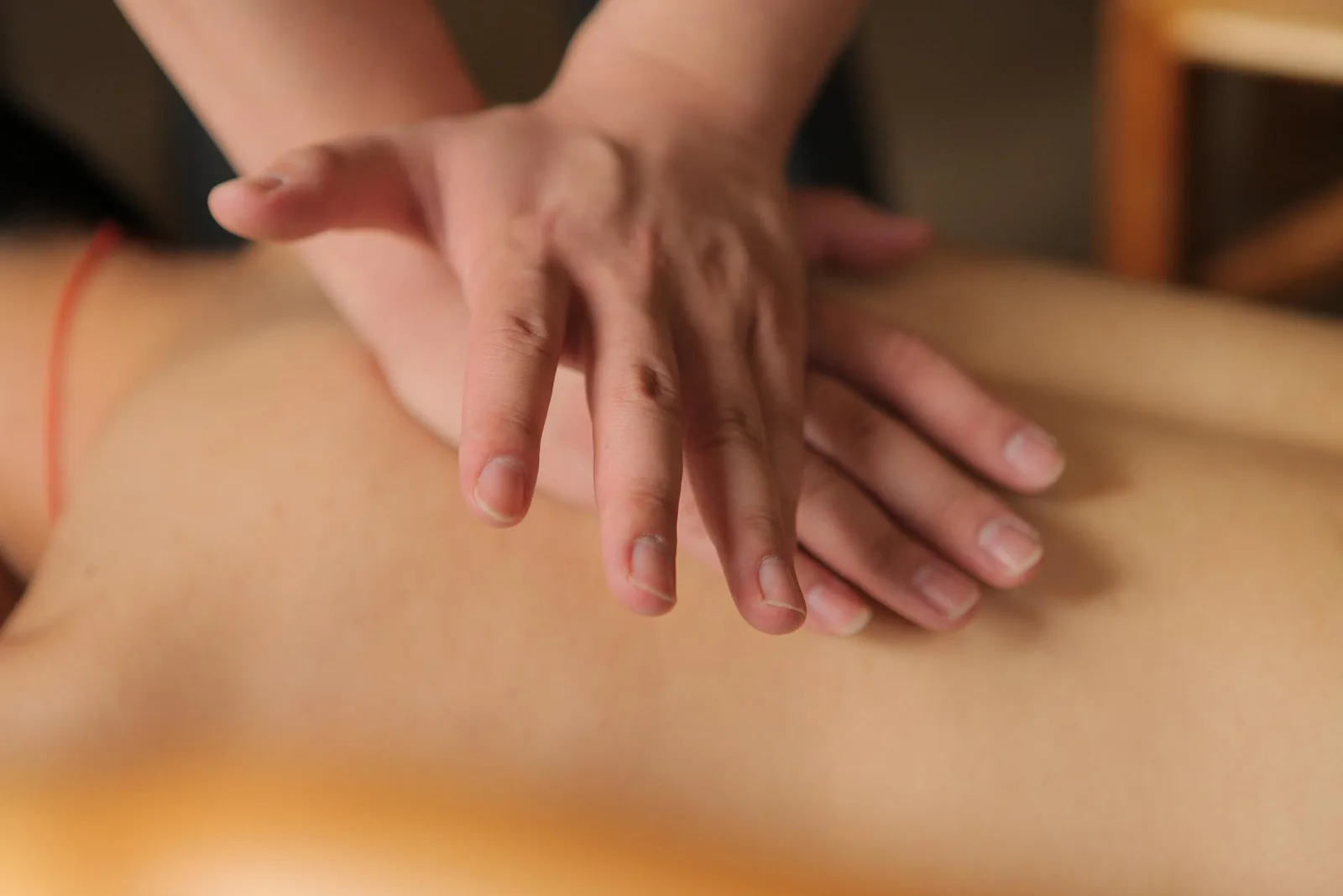 Therapeut führt Marmapunkt-Massage an der Schulter eines Patienten durch