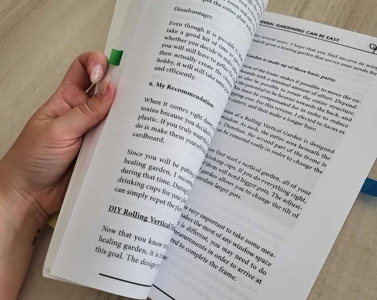 Aufgeschlagenes Buch mit Textseiten und grünem Stift in weiblicher Hand