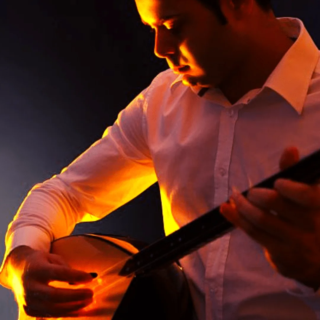 Cemil Aydemir spielt Baglama mit dramatischer Beleuchtung, Porträt