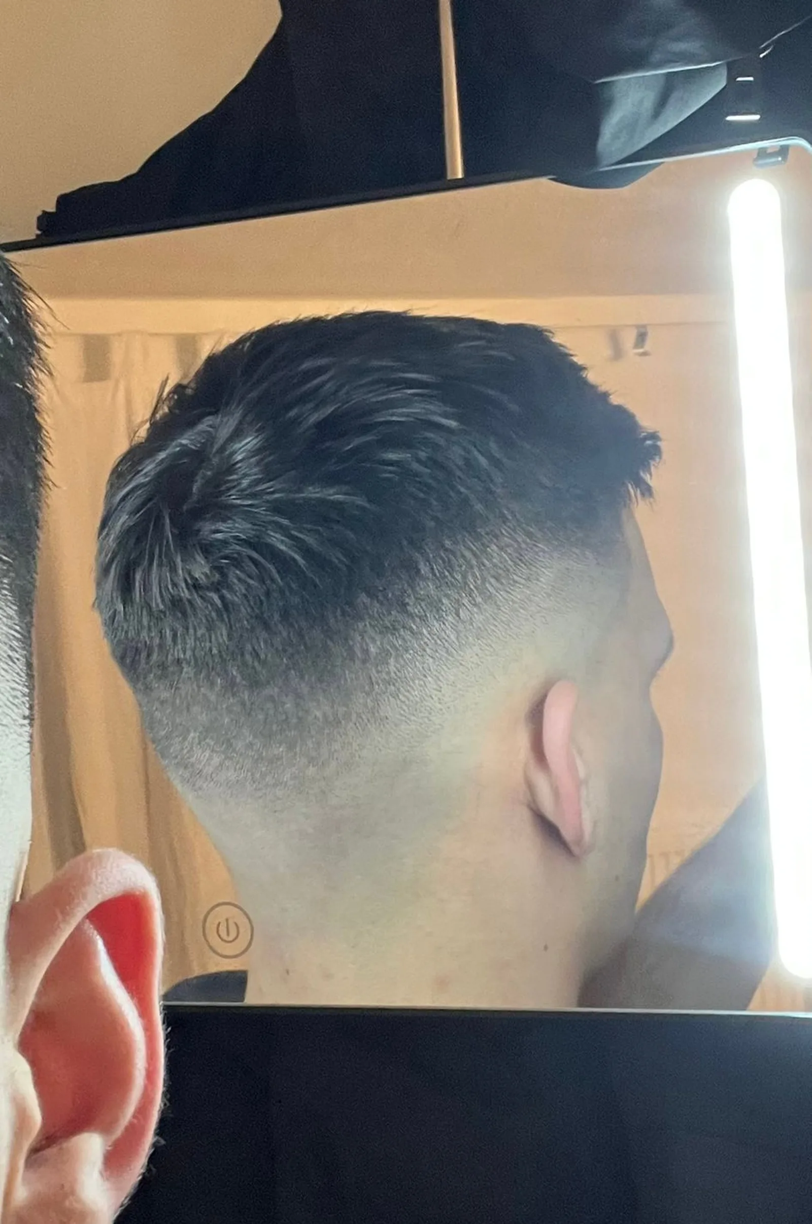 Seitenprofil mit Haarschnitt vor beleuchtetem Spiegel, Barber Academy Werk