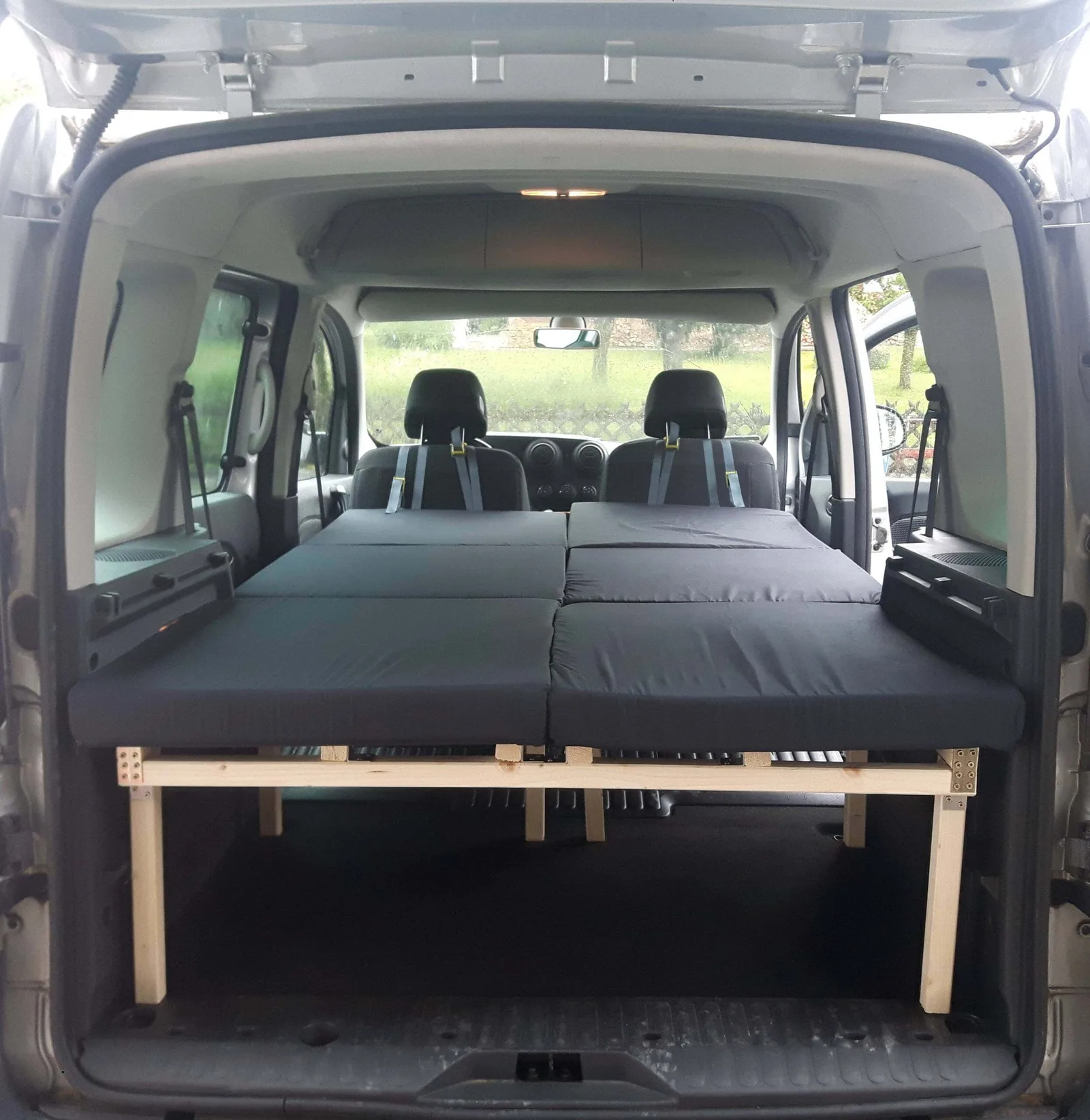 Citroen Berlingo II mit ausgebautem Doppelbett, schwarze Matratze auf Holzgestell mit Stauraum