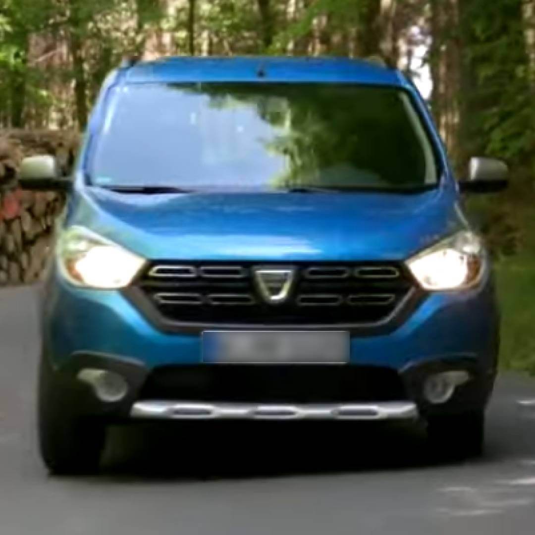 Blauer Dacia Lodgy von vorne auf Waldweg geparkt