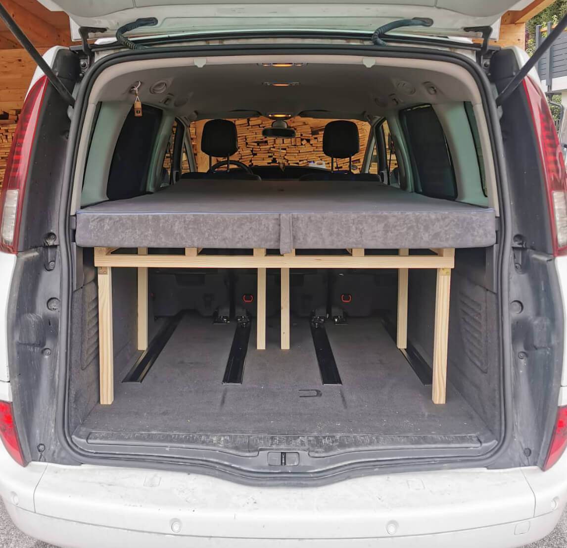Renault Grand Espace mit Doppelbett auf Holzrahmen und Stauraum-Boxen unten
