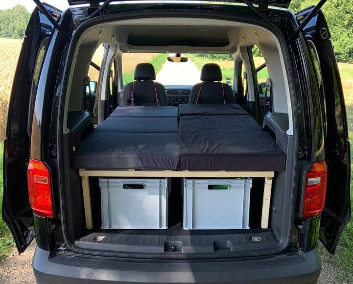 VW Caddy mit ausgezogenem Kombibett, Matratze über zwei Lagerboxen, Innenansicht