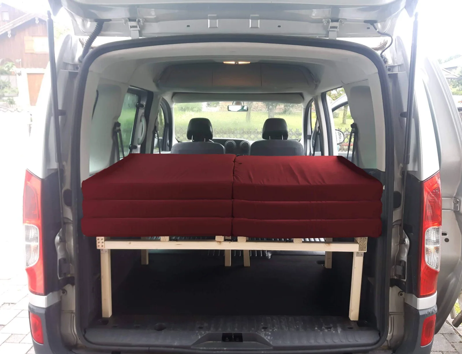Rotes Kombibett in weißem Renault Kangoo W eingeklappt, Fahrt-Position