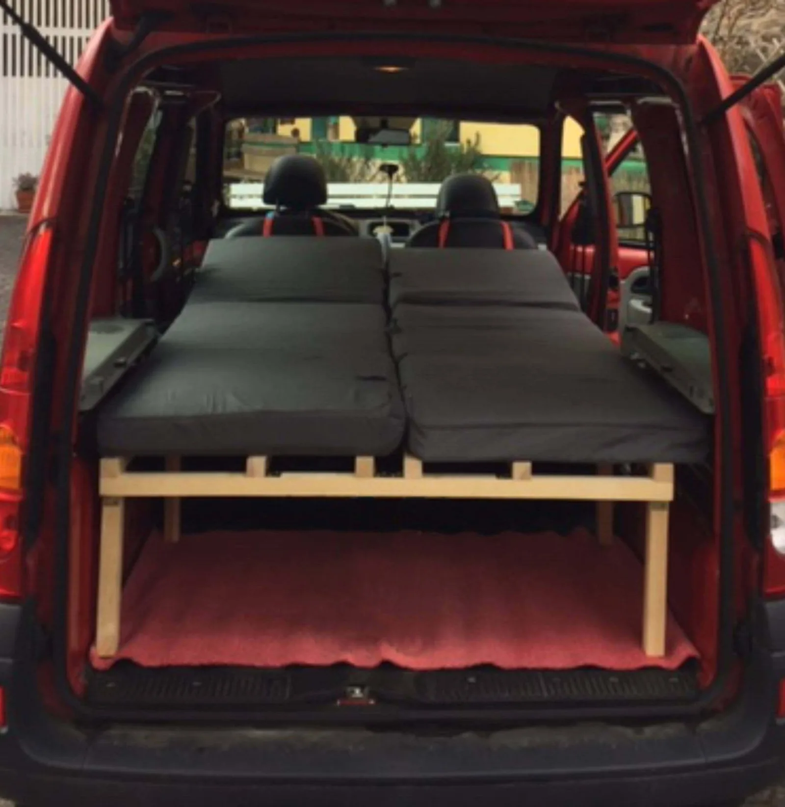 Roter Renault Kangoo mit ausklappbarem Kombibett von hinten offen