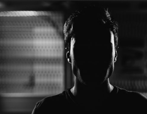 Silhouette eines Mannes vor dunklem Hintergrund, dramatische Schwarz-Weiß-Aufnahme
