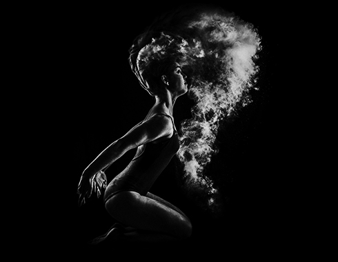 Frau im Profil mit Partikeln, die vom Kopf ausströmen, Schwarz-Weiß-Kunstfotografie