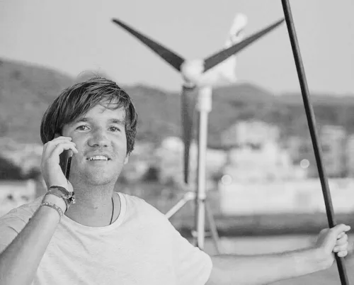 Mann am Telefon vor Windkraftanlage in Schwarzweiß