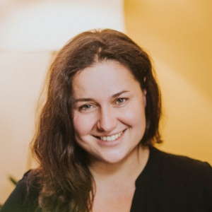 Portrait von Ana Hermannsdörfer, Frau mit braunem Haar und Lächeln