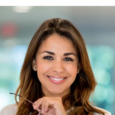 Best Life – 1:1 Coaching gegen Erschöpfung von Gina Heller 3 Porträt einer lächelnden Frau mit braunem Haar vor unscharfem Hintergrund