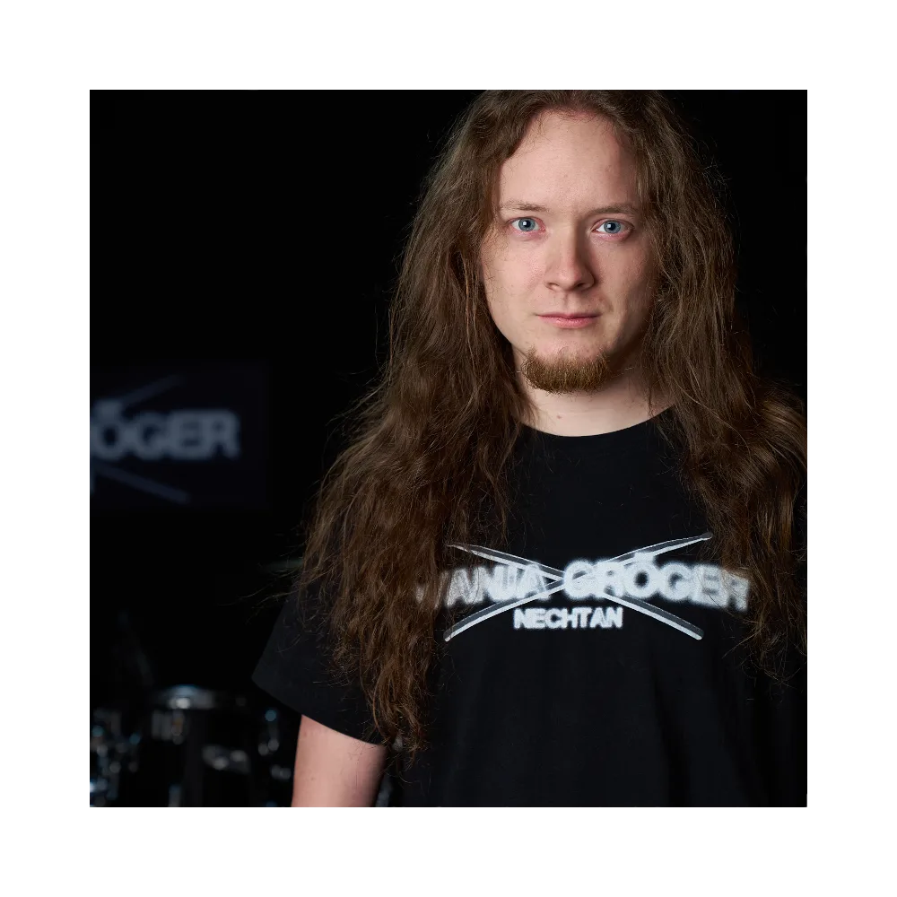 Porträt Wanja Gröger mit langen braunen Haaren und Wanja Gröger Nechtan T-Shirt vor schwarzem Hintergrund