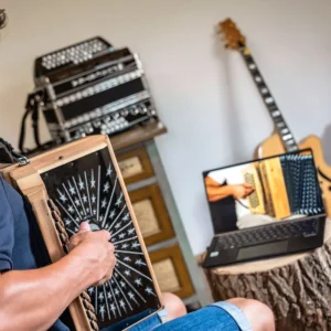 Harmonika-Videokurs Szenerie mit Steirischer Harmonika, Gitarre und Laptop-Bildschirm in Nahaufnahme
