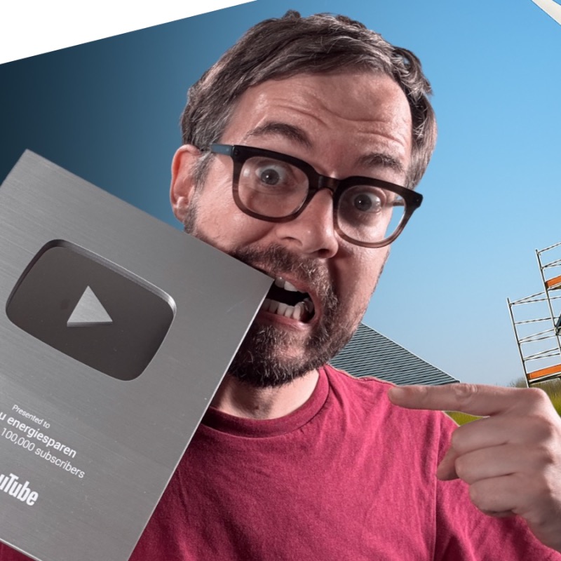 Alexander Boerger mit Brille und Pink-Shirt hält YouTube-Goldplakette, lächelt überraschend
