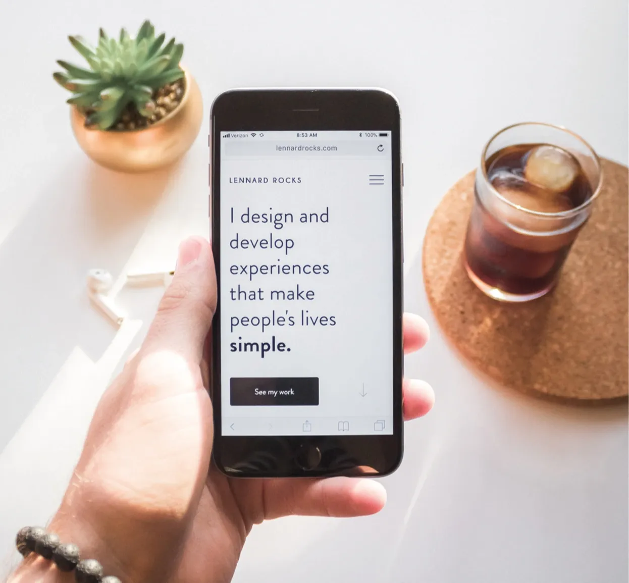 Hand hält Smartphone mit Webseite lennard rocks - I design and develop experiences that make people's lives simple