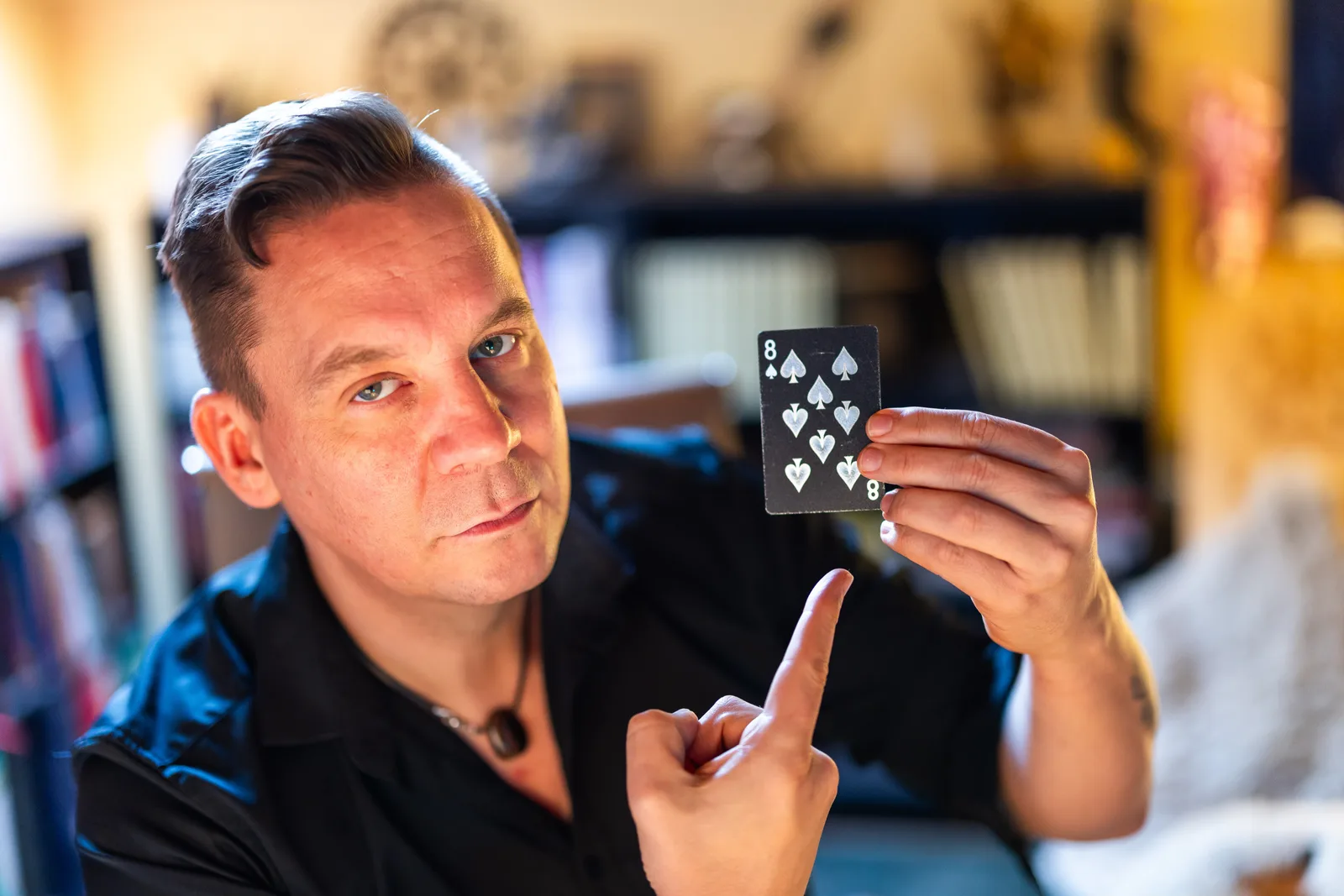 René Rink hält Tarot-Karte 8 Pik in die Kamera und erklärt Kartenbedeutung